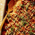 Close up on a baking dish of sushi bake recipe with a spoon in it.