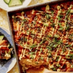 Salmon sushi bake in a baking dish with cucumbers and nori.