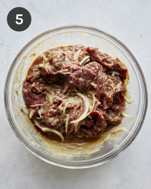 Beef mixed together in a bowl with marinade to make Korean bulgogi.