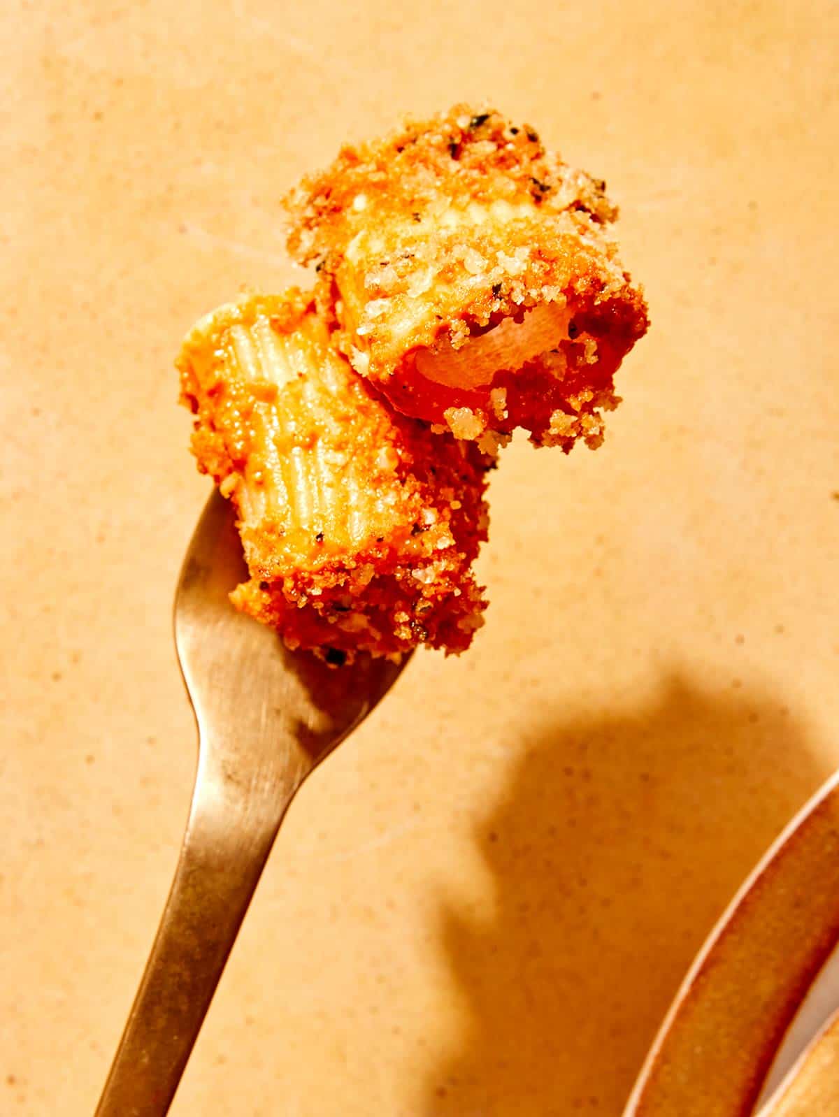 Romesco sauce pasta speared on a fork. 