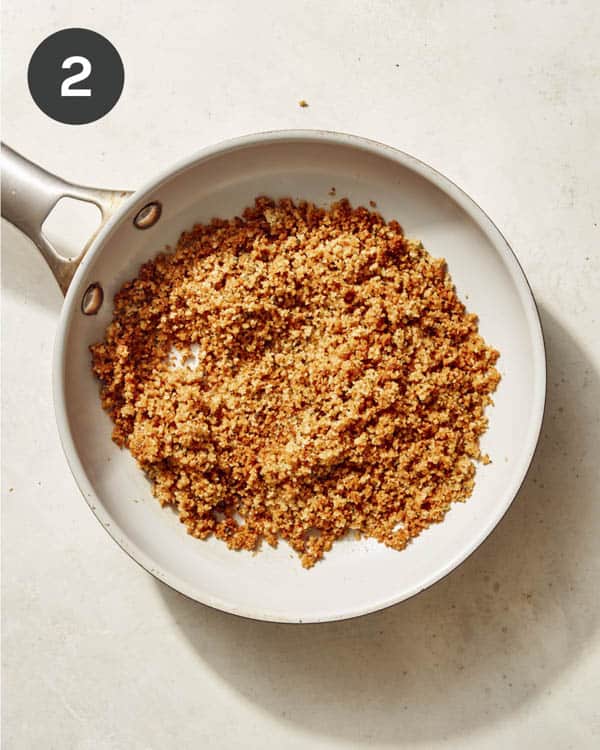 Breadcrumbs toasting in a skillet.