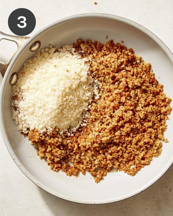 Breadcrumbs mixed with parmesan in a skillet. 