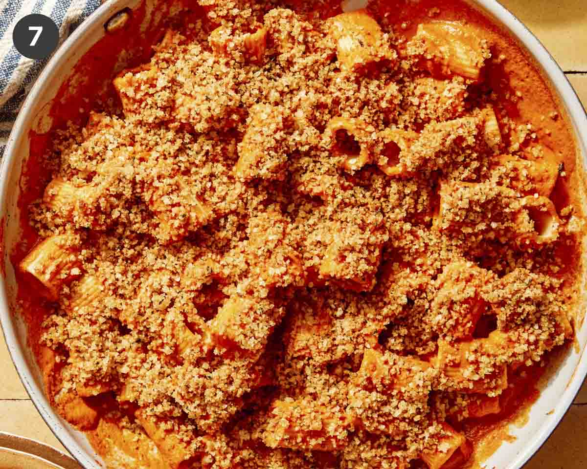Close up in a skillet of romesco sauce with breadcrumbs on top. 