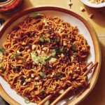 Spicy ramen noodles in a bowl with chopsticks.