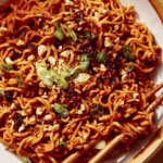 Spicy ramen noodles in a bowl with chopsticks.