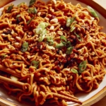 Spicy ramen noodles in a bowl with chopsticks.