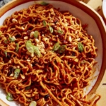 Spicy ramen noodles in a bowl with chopsticks.