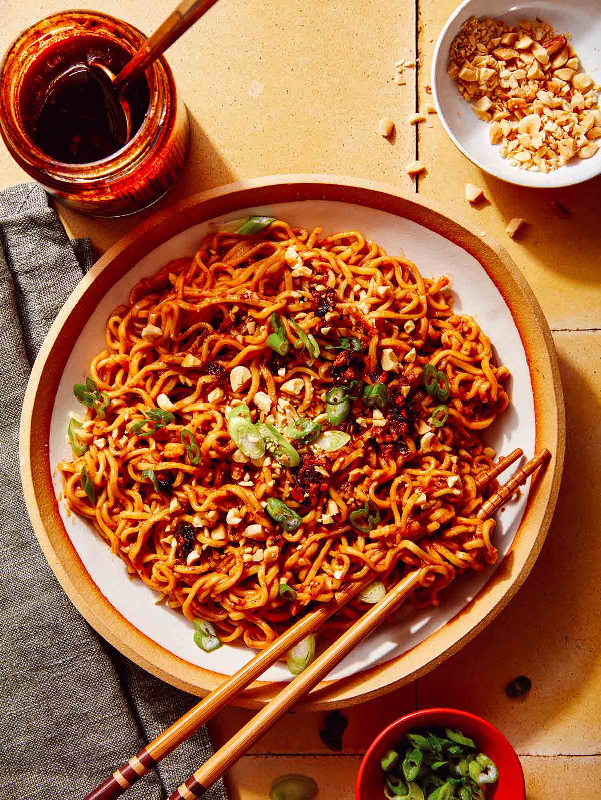 Spicy ramen noodles in a bowl with peanuts and green onions on top.