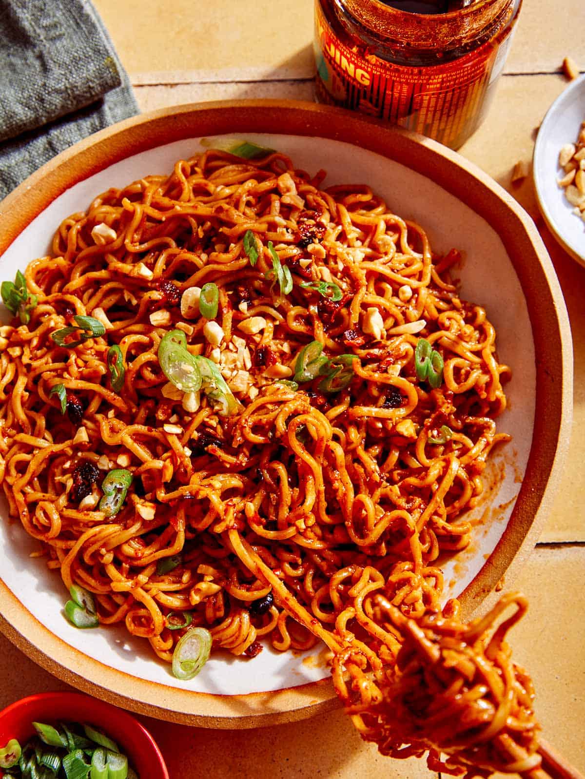 Spicy ramen noodles being eaten with chopsticks.
