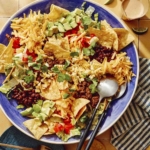 Taco salad in a big bowl with a plate on the side.