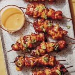 Air fryer bang bang chicken skewers with dipping sauce.