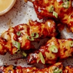 Air fryer bang bang chicken skewers with dipping sauce.