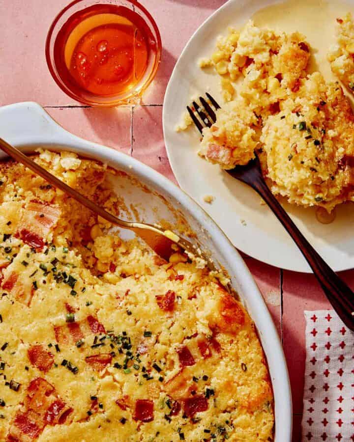 Corn casserole recipe with some scooped out on a plate.