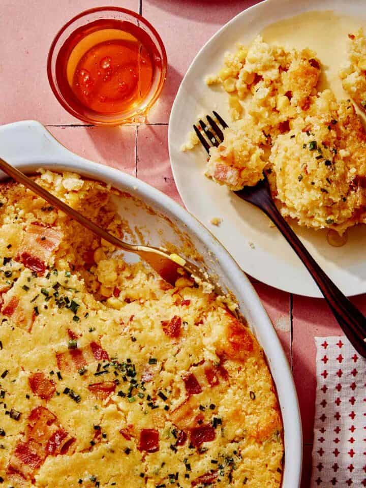 Corn casserole recipe with some scooped out on a plate.