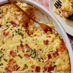 Corn casserole recipe with some scooped out on a plate.