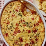 Corn casserole recipe with some scooped out on a plate.