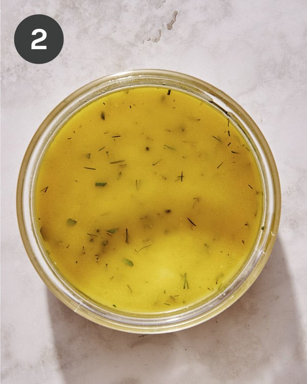Herb vinaigrette dressing in a bowl freshly whisked together.