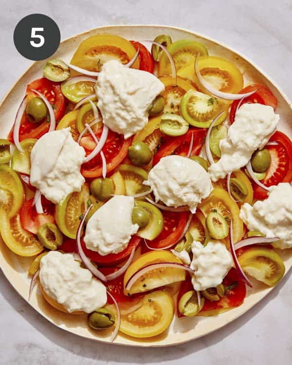 Tomato salad ingredients on a plate spread out.