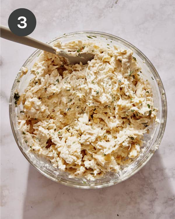 Crab dip recipe ingredients being mixed in a bowl.