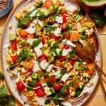 Corn salad on a platter with basil vinaigrette on the side.