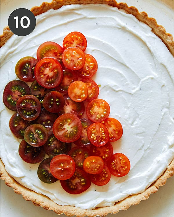 Heirloom tomato tart being filled with tomatoes.