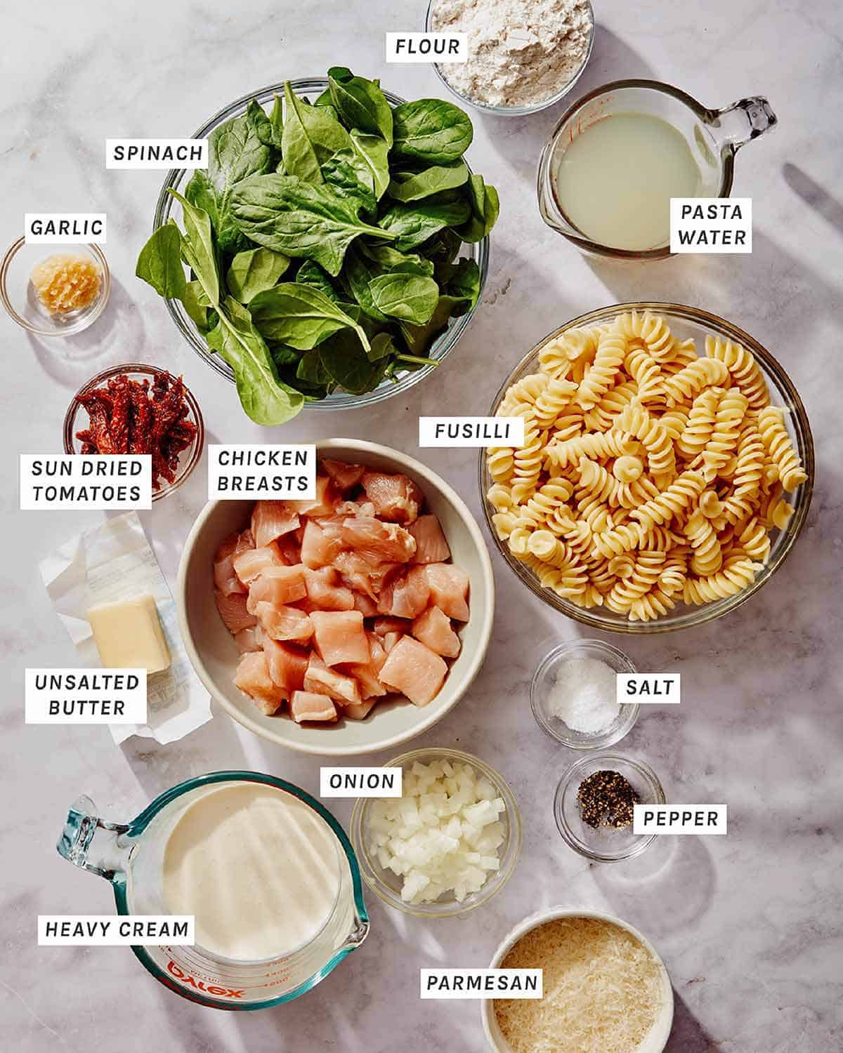 Tuscan chicken pasta ingredients on a kitchen counter. 