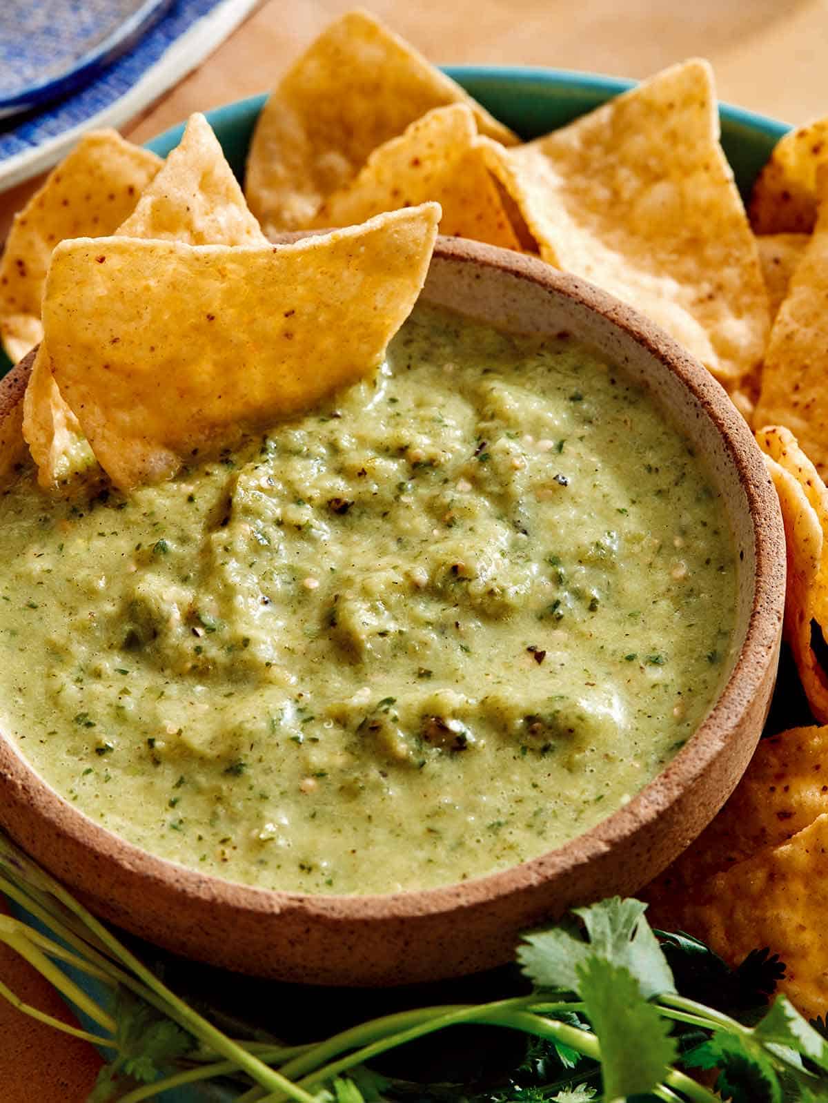 Tomatillo salsa dubenyje su traškučiais patiekiama ant šono.