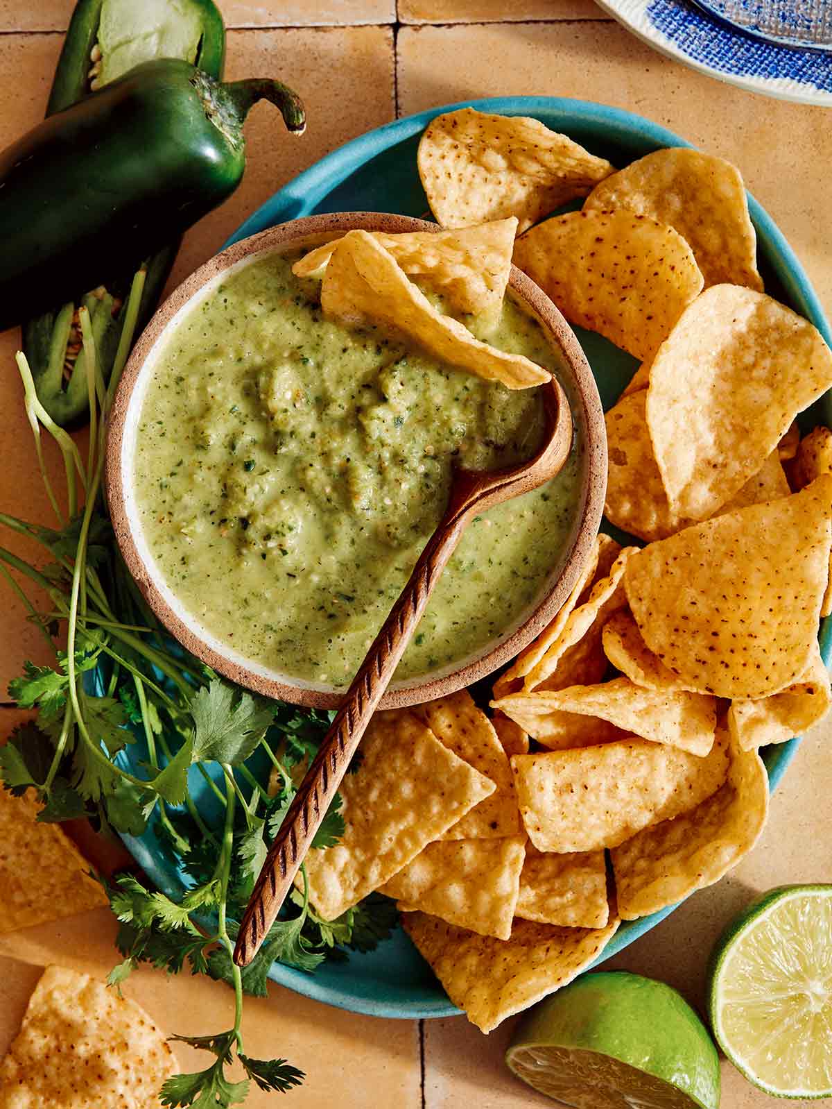 Patiekiama Tomatillo salsa dubenyje su šaukštu.