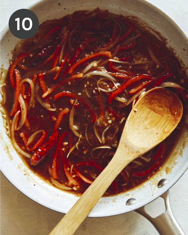 Szechuan beef sauce with peppers in a skillet.