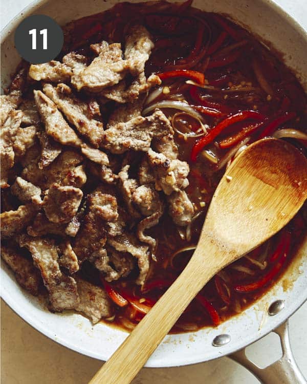 Szechuan beef sauce with peppers in a skillet.