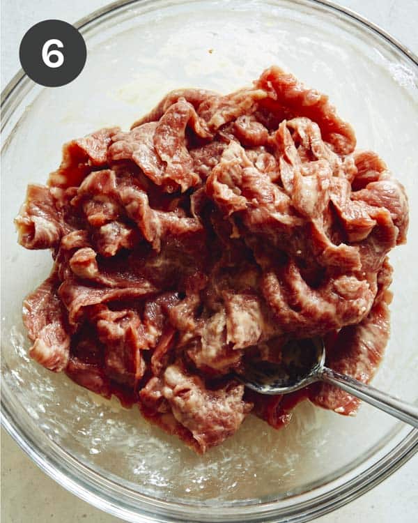 Szechuan beef mixed with cornstarch in a bowl.