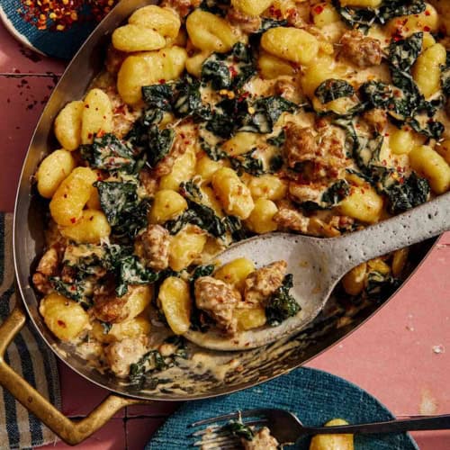 Baked gnocchi being scooped out onto a plate.