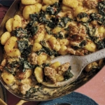 Baked gnocchi being scooped out onto a plate.