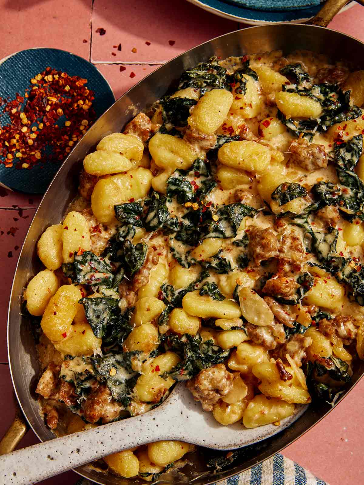 Kepti gnocchi su raudonųjų pipirų dribsniais šone.