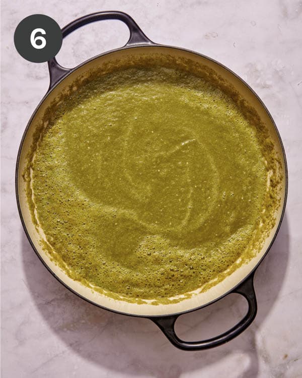 Chicken pozole verde soup base simmering in a pot.
