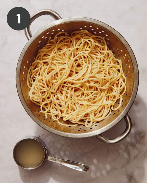 Pasta drained with some pasta reserved on the side.