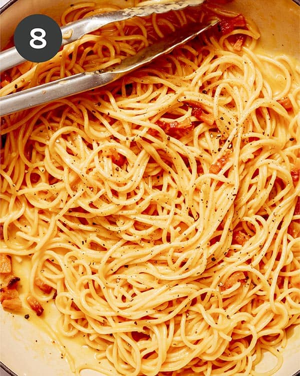 Carbonara in a skillet being tossed.