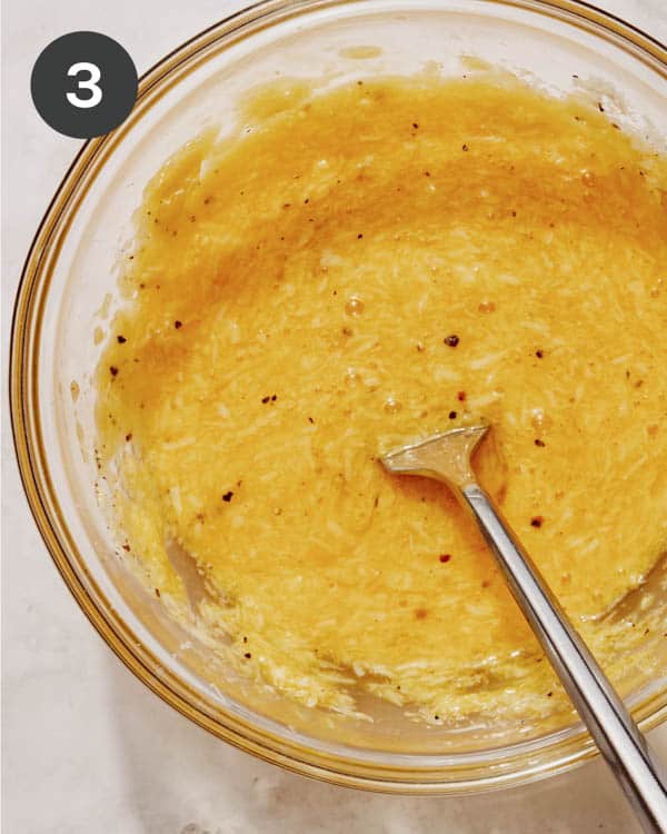 Egg yolk and cheese mixture in a bowl mixed together.
