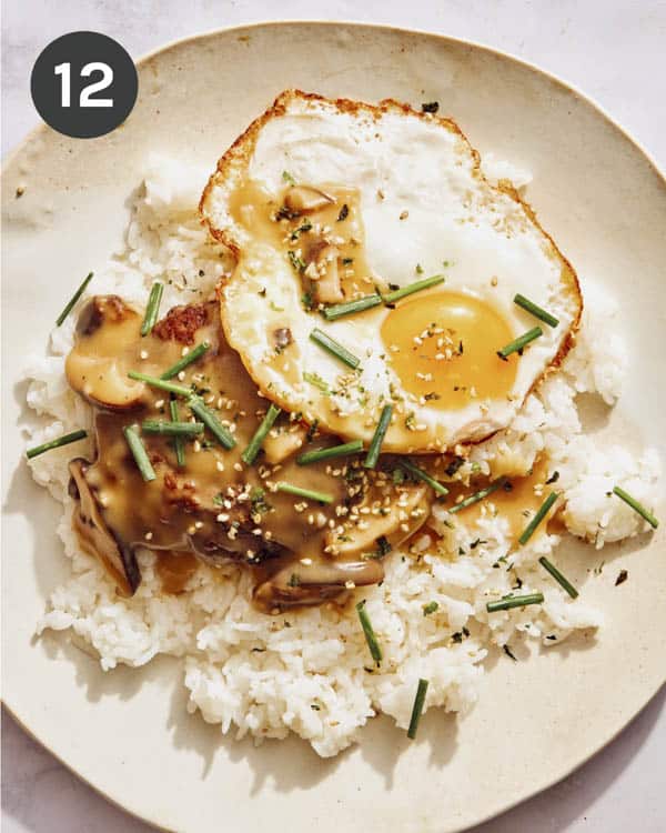Loco Moco on a plate with chives and furikake on top.