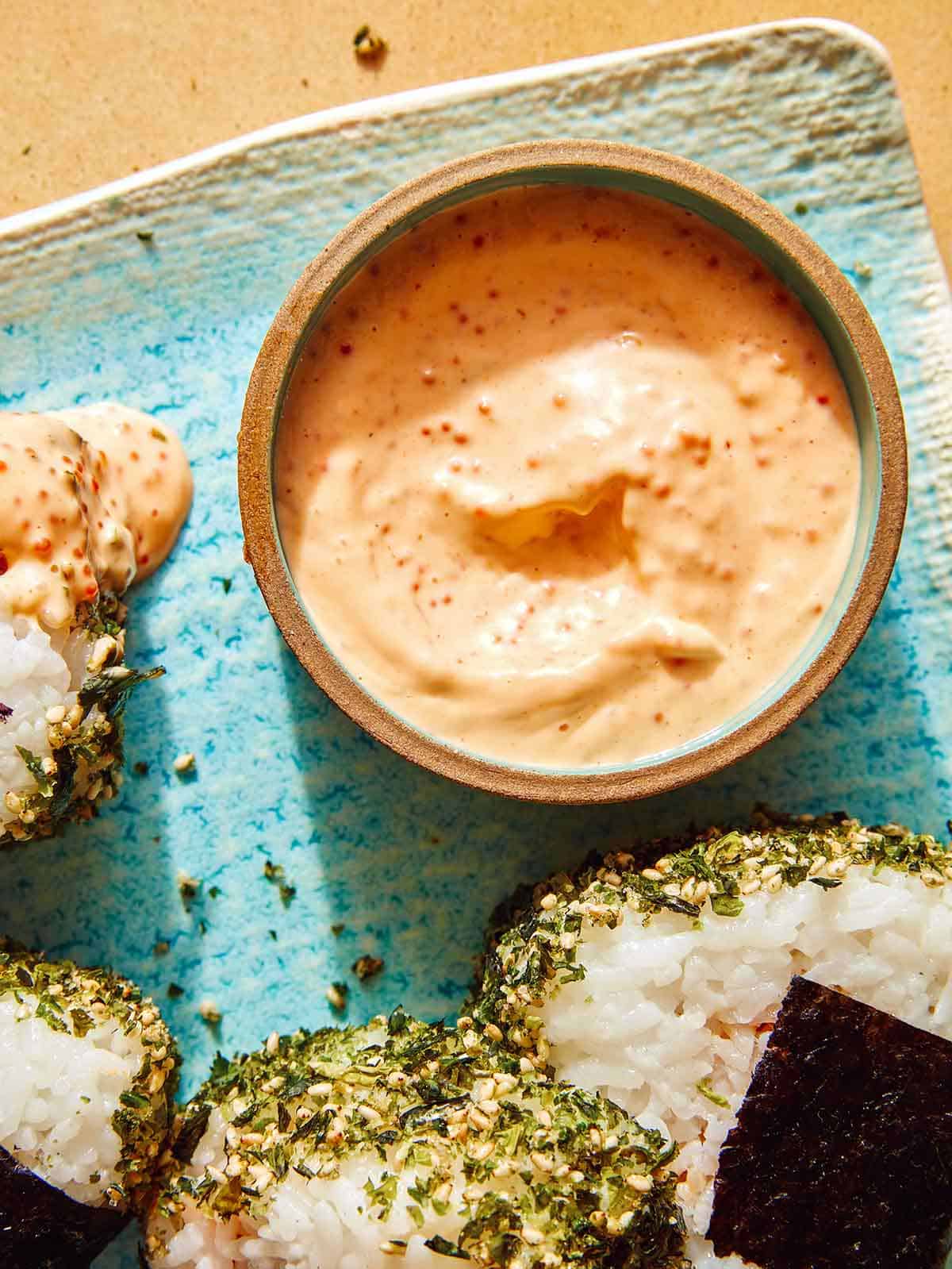 Masago sauce in a ramekin with onigiri on the side.