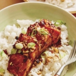 Soy glazed salmon on a bed of rice with a fork.