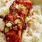 Soy glazed salmon in a bowl with rice and toppings.