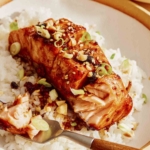 Soy glazed salmon with rice and a bite taken out of the salmon fillet.
