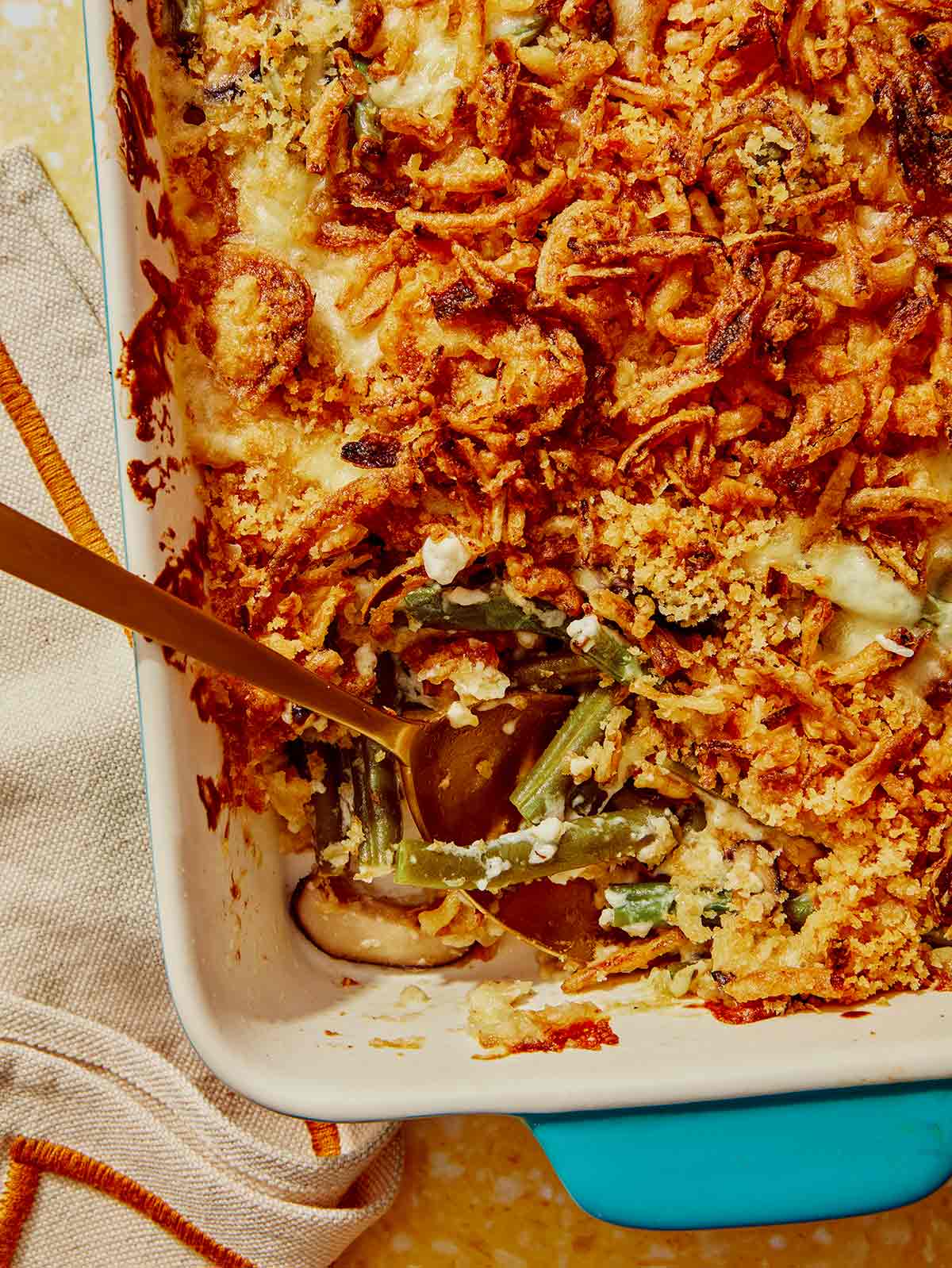 Close up on a green bean casserole with a serving taken out of it.