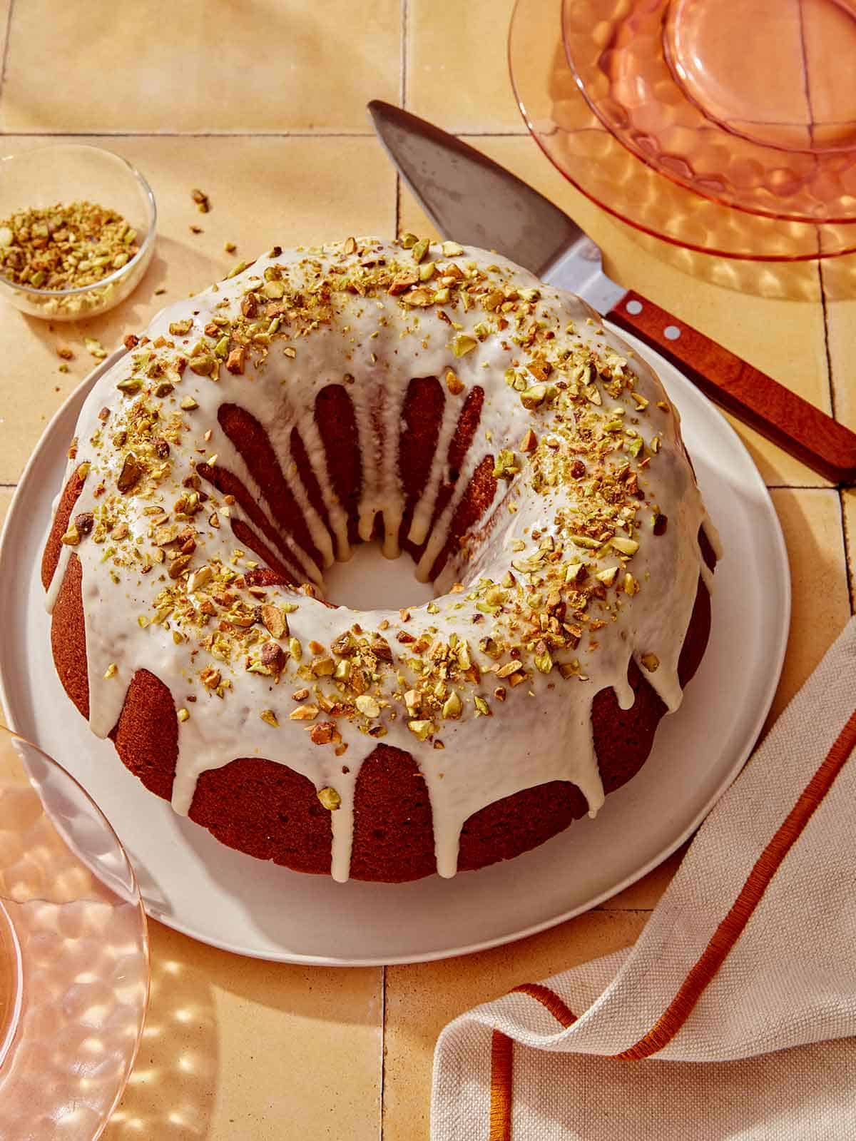 Pumpkin cake with a pistachio glaze on a serving platter.