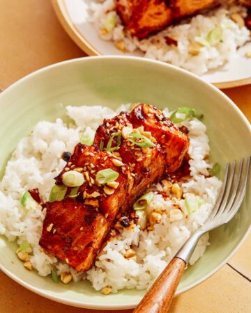 Soy glazed salmon on a bed of rice with a fork.