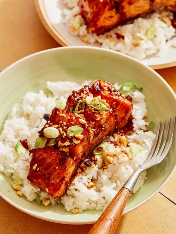 Soy glazed salmon on a bed of rice with a fork.