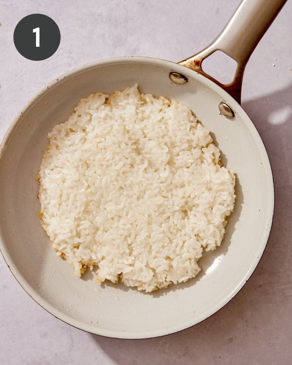 Rice being cooked in a skillet. 