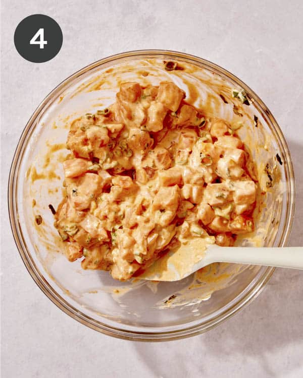 Spicy salmon in a glass bowl mixed together.