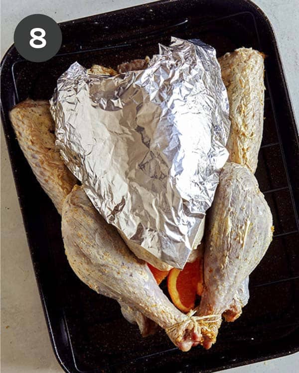 A turkey with a breast covered in tin foil.